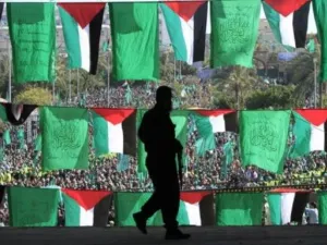 رجل يمر من امام اعلام ومتظاهرين في غزة