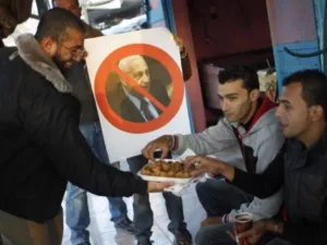 فلسطينيون يوزعون حلوى في شوارع غزة احتفالا بوفاة شارون/أ.ف.ب