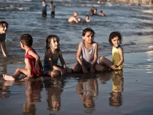 Children play in the water in Gaza City (AFP/File Photo)