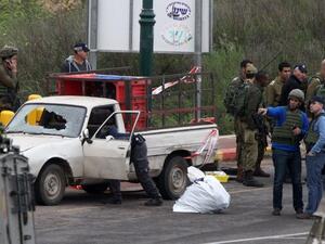 Israeli security forces stand guard at the scene where three Palestinians carried out two attacks -- a shooting and a car ramming -- on Israelis at the entrance of the Israeli settlement of Kiryat Arba near Hebron on March 14, 2016. (AFP/Hazem Bader)