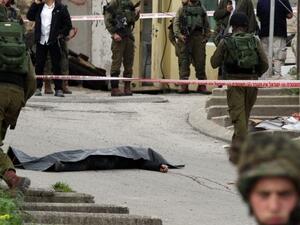 Israeli soldiers surround the body of one of the two Palestinians who were killed after attacking a soldier in Hebron, March 24, 2016. (AFP/File)