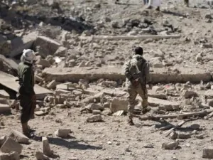 مقاتلان من الحوثيين في منطقة شهدت ضربة جوية للتحالف الذي تقوده السعودية في صنعاء 
