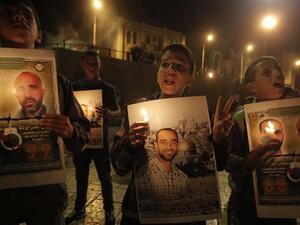 Palestinians hold prisoners’ pictures and candles during a protest calling for the release of Palestinian inmates from Israeli jails and in support of prisoners on hunger strike in al-Quds (Jerusalem) on October 12, 2012. (AFP/File)