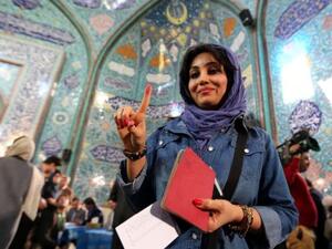 An Iranian woman voting in Iran's elections shows her inked finger after casting her ballot at a polling station in Tehran, February 26, 2016. (Photo: AFP)