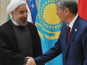Kyrgyzstan's President Almazbek Atambayev shows the way to his Iranian counterpart Hassan Rowhani at a summit of the Shanghai Cooperation Organization. [AFP]