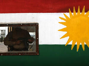 A member of the Iraqi Kurdish Peshmerga forces stands guard in a post bearing the colours of the Kurdish flag in Khazir, near the Kurdish checkpoint of Aski Kalak, 40 kilometres West of Arbil. (AFP/File)