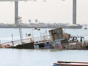 A picture taken in the southeastern Iraqi city of Basra shows a small casino boat that sank in the Shatt al-Arab river after a small device exploded nearby during the night.  (AFP/File)