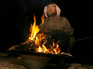An Iraqi Bedouin sits next to a fire during a traditional wedding ceremony in the desert some 400km from the southern Iraqi city of Samawa. (AFP/File)