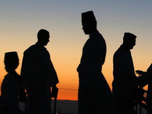 The sun rises as Samaritan worshipers gather to pray on top of Mount Gerizim, near the northern West Bank city of Nablus, to celebrate the Shavuot festival. (AFP/File)
