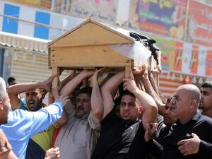 Iraqis carry the coffin of one of the victims of the attack on a Shiite mosque. [AFP]