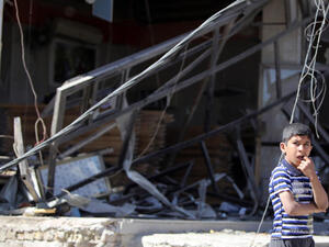 An Iraqi boy stands at the site the morning after a car bomb attack. (Image credit: AFP)