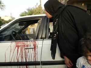 An Iraqi woman looks into a blood stained car of two women shot dead in central Baghdad earlier this month. [presstv]