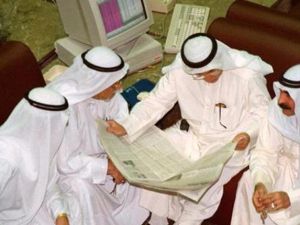 مجموعة من الكويتيين يستعرضون صحيفة داخل البورصة بالكويت العاصمة
