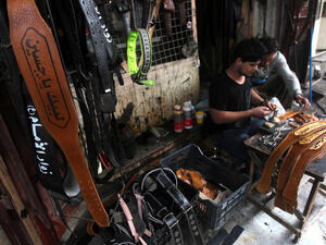 An Iraqi youth makes a belt especially for the annual Shiite Muslim commemoration of Ashura with the saying embossed in Arabic that reads, "Labaik ya Hussein" or " In your service Hussein." (Image credit: AFP)