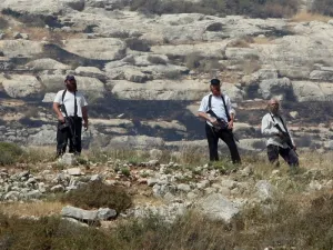 Armed settlers overlook a Palestinian village south of Nablus during confrontations following the setting on fire of Palestinian-owned fields on Jan. 1, 2010. (AFP/Jaafar Ashtiyeh)