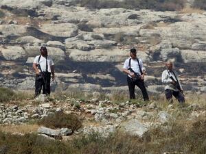 Armed settlers overlook a Palestinian village south of Nablus during confrontations following the setting on fire of Palestinian-owned fields on Jan. 1, 2010. (AFP/Jaafar Ashtiyeh)