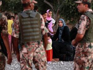 Jordanian soldiers watch over Syrian refugees fleeing violence in their country after they crossed into Jordanian territory with their families from Syria into Jordan. [haaretz]