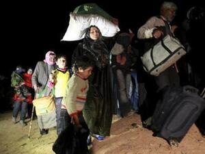 In darkness, Syrian refugees stream across country borders. [Reuters]