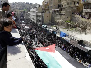 Thousands of Jordanians hold a giant national flag during a demonstration on March 4, 2011, in Amman to demand "regime reforms," a day after Prime Minister Maaruf Bakhit rejected calls for a constitutional monarchy. (AFP/Khalil Mazraawi)
