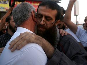 Khader Anan embraces his father after being released from jail, a day before being re-arrested in Old Jerusalem. (AFP/Jaafar Ashtiyeh)