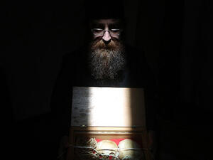 A Greek Orthodox monk holds a box at Our Lady of Hamatoura Monastery in northern Lebanon containing the remains of a boy reportedly killed and found in the ruins of the monastery. (AFP/File)