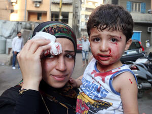 A boy and his mother are seen at the site of a car bomb between the Bir el-Abed and Roueiss neighborhoods, in the southern suburb of Beirut (AFP/STR)