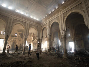 Residents walk through debris and rubble inside the burnt-down mosque of Rabaa al-Adawiya (AFP/KHALED DESOUKI)