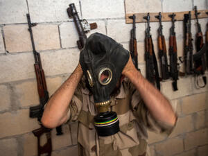 A Syrian rebel tries on a gas mask seized from a Syrian army factory in the northwestern province of Idlib (AFP/DANIEL LEAL-OLIVAS