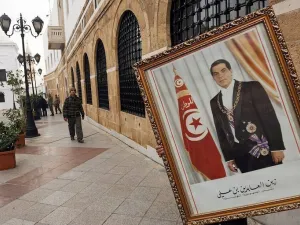 عامل يزيل صورة للرئيس التونسي المخلوع زين العابدين بن علي من مكتب رئيس الوزراء في تونس
