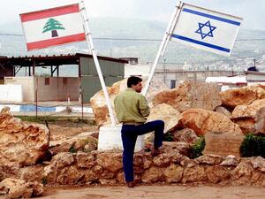 An off-duty Israeli soldier looks across the Israeli-Lebanon border (Shutterstock/Northfoto)
