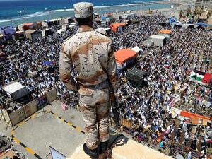 A Libyan rebel stands guard on top of a roof overlooking thousands performing noon prayers in Revolution Square in Benghazi on May 13, 2011. (Saeed Khan/ AFP) A Libyan rebel stands guard on top of a roof overlooking thousands performing noon prayers in Revolution Square in Benghazi on May 13, 2011. (Saeed Khan/ AFP)