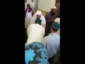 آسيوييون يقبلون يد امام مسجد بمكه ويتبركون بشرب الماء من بعده