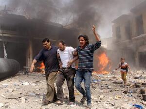Syrian men help an injured person following a reported barrel bomb attack by Syrian government forces that hit an open market in the northern city of Aleppo, on June 3, 2015, killing and injuring people. (AFP/Karam al-Masri)