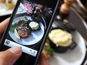 A man photographs his meal with a cell phone. Photograph by Ana Arevalo. AFP