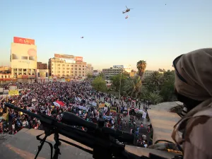 A member of the Iraqi security forces watches over protesters as they demonstrate in support of Prime Minister Haider al-Abadi's reforms. (AFP/Haidar Mohammed Ali)