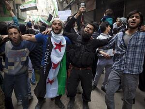 Syrian men dance and chant revolutionary slogans during the commemoration of the second anniversary of the Syrian conflict, in Bustan al-Qasr district of Aleppo. (AFP PHOTO/JM LOPEZ)