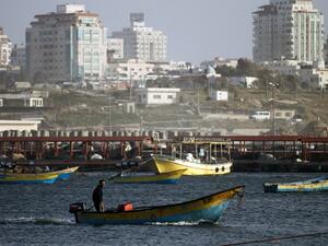 A Palestinian fisherman rides a boat near the port of Gaza City on March 22, 2013. Israel cut the distance from the shore that Gaza fishermen are allowed to sail from six to three miles and shut the Kerem Shalom goods crossing from Israel into the Gaza Strip in response to a rocket attack against southern Israel. (AFP PHOTO/MOHAMMED ABED)