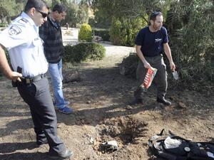 A bomb technician collects the remains of a rocket launched from Gaza Strip falling close to Sderot on April 3, 2013. Israeli aircraft carried out apparent warning strikes in the Gaza Strip, hitting empty fields after a militant rocket earlier struck waste ground in southern Israel. (AFP PHOTO/DAVID BUIMOVITCH)