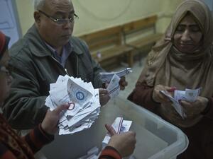 Polling station officials count ballots in the Egyptian capital Cairo on January 15, 2014 at the end of the second day of voting in a referendum on a new constitution. [AFP]