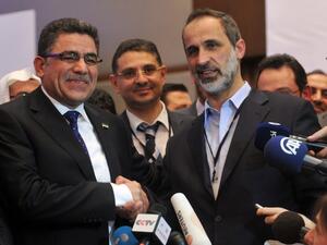 Syria's main opposition National Council chief Moaz al-Khatib (L) congratulates Syrian communications executive, Ghassan Hitto, after the National Council elected him as prime minister. (AFP PHOTO/OZAN KOSE)