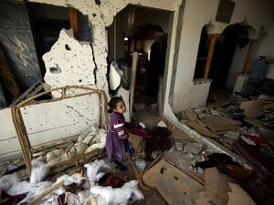 A Palestinian girl is seen inside the destoryed home of three-year-old Hala Abu Sabakha, who was killed during an Israeli air raid the day before, in the central of Gaza Strip, on December 25, 2013. [AFP]