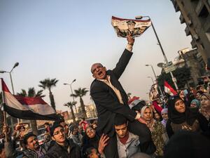 An Egyptian man holds a portrait of Egypt's Defense Minister General Abdel Fattah al-Sisi outside a polling station during the vote on a new constitution. [AFP]