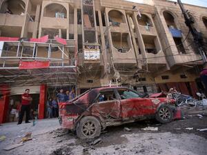 Iraqi civilians check the site of an explosion in Baghdad on Wednesday. Coordinated car bombs ripped through mostly Shiite neighbourhoods in the Baghdad area during rush hour, killing at least 30 people, the latest in spiralling violence in recent months. (AFP)