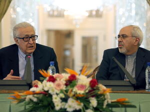 Iranian Foreign Minister Mohammad Javad Zarif  listens to International Peace envoy to Syria Lakhdar Brahimi during a joint press conference in Tehran on October 26, 2013. [AFP]