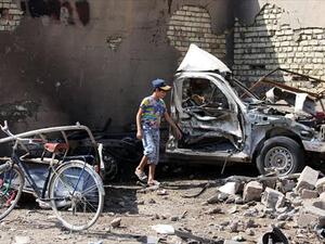 An Iraqi child stands by the wreckage of a burnt car on the site of a car bomb explosion in the city of Suweirah, south of Baghdad, on Sunday. A wave of attacks across Iraq, including more than a dozen car bombs, killed at least 30 people while the head of Baghdad's provincial council escaped assassination. (AFP)