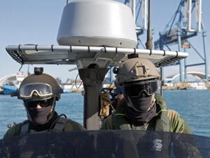 Members of the Norwegian navy special forces monitor the water around the Norwegian naval frigate 'Hnoms Helge Ingstad' off the Cypriot port city of Limassol on December 14, 2013. [Getty Images]