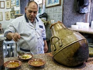 Just about everything at Hashem Restaurant exudes the grittiness of this city's rough-and-tumble downtown: chefs in white aprons
scoop fuul (fava beans) out of vase-shaped metal jars and plop it on to plastic bowls.