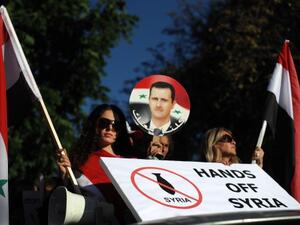  Protesters hold pictures of Syrian President Bashar al-Assad and banners against a potential air strike against Syria in front of the US Embassy in Sofia on September 4, 2013. (AFP)