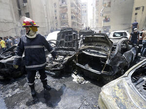 A firefighter stands after extinguishing fire from vehicles at the site of an explosion in Beirut's southern suburb neighbourhood of Bir al-Abed on July 9, 2013. (Source: AFP/STR)