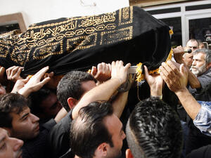 Mourners carry the body of Hassan Ramadan, who was killed in a blast in Beirut earlier in the week, during a funeral in the southern Lebanese village of Jwaya (AFP/MAHMOUD ZAYYAT)